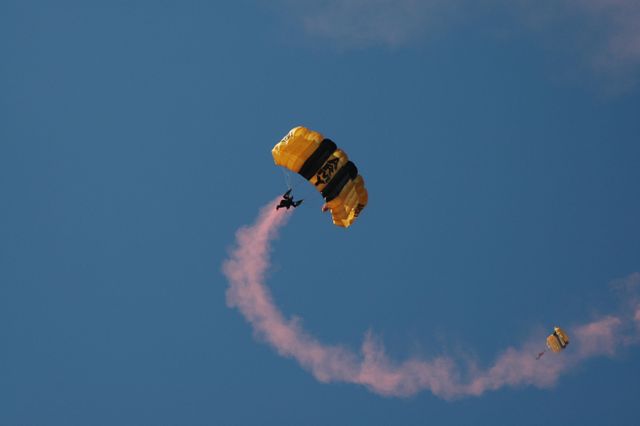 U.S. Army Golden Knights performing skydiving at World Space Expo above Kennedy Space Center with blue sky background. This can be used in articles about skydiving shows, military performances, or space event celebrations.
