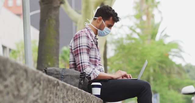 Young Man Working on Laptop Outdoors Wearing Mask - Download Free Stock Images Pikwizard.com