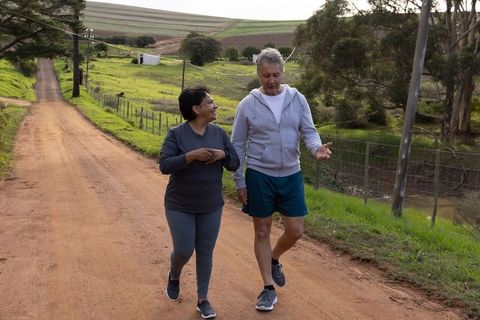 Middle-aged Couple Enjoying Scenic Walk on Rural Farm Pathway