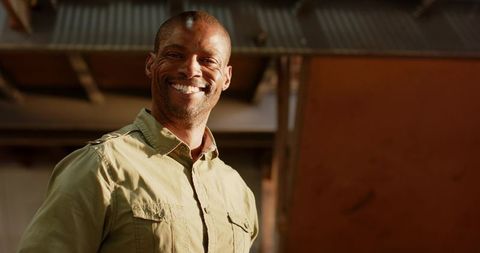 Confident worker in industrial setting with corrugated roof