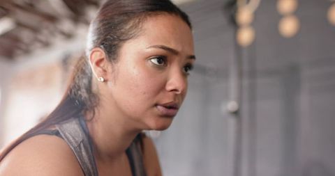 Focused female athlete concentrating during gym workout closeup showing determination