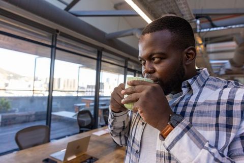 Businessman Enjoys Relaxing Coffee Break in Modern Office