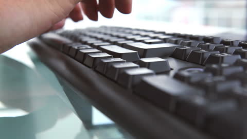 Close Up of Hands Typing on Keyboard in Workplace
