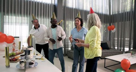 Mixed ethnicity colleagues celebrating office party with sparklers