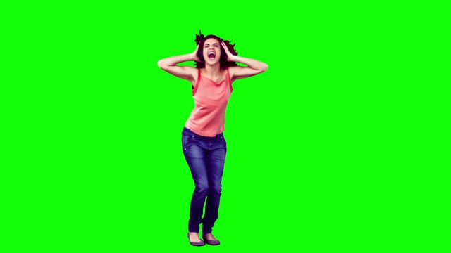 Happy woman dancing with enthusiasm against green background can be used for concepts of joy, celebration, happiness, or lively activities. Ideal for promotional materials, advertisements, social media posts, or content requiring vibrant energy and positivity.