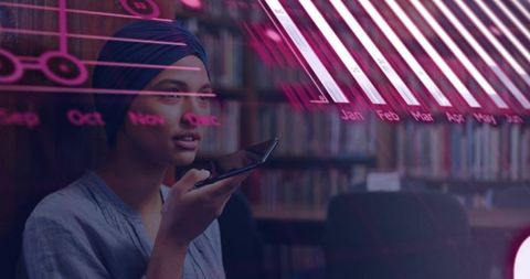 Turbaned woman speaking on smartphone with data charts overlaying library, analytics