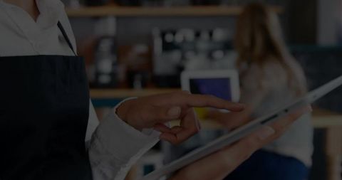 Barista Using Digital Tablet at Modern Cafe Counter