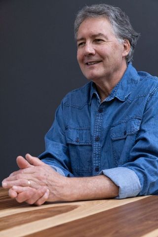 Senior Man in Denim Shirt Relaxing at Wooden Table