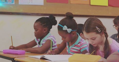 Diverse Students Writing in Classroom Focused on Learning