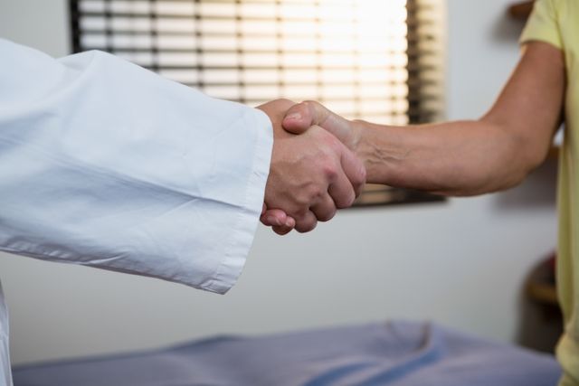 Physiotherapist shaking hand with patient in clinic