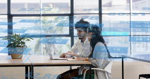 Coworkers collaborating and analyzing data dashboards on laptop in modern office