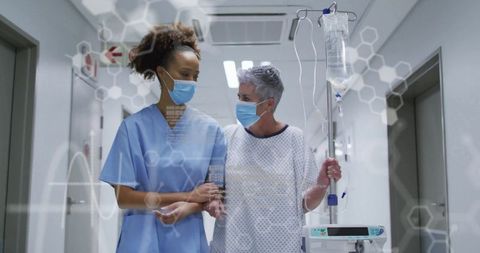 Nurse Providing Care to Senior Patient in Hospital Corridor
