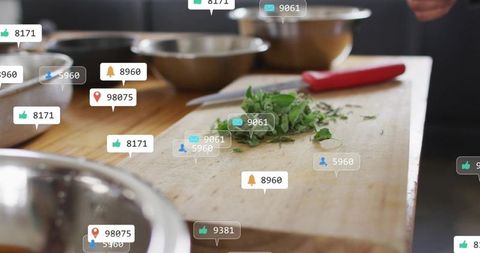 Chef chopping fresh herbs on wooden board with red knife and floating social media alerts