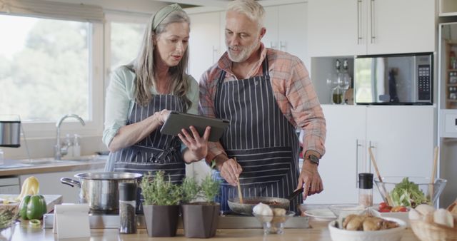 Senior Couple Cooking Together and Using Digital Tablet in Kitchen - Download Free Stock Images Pikwizard.com