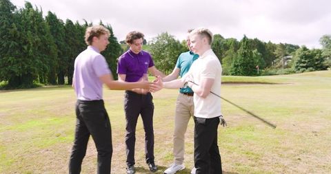 Golfers shaking hands on fairway celebrating friendly round, teamwork and sportsmanship