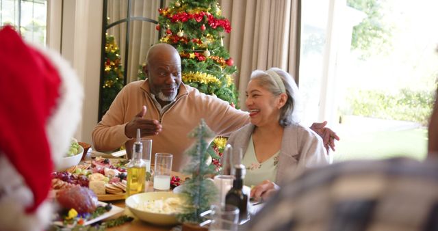 Senior couple enjoying Christmas meal with family at festive table - Download Free Stock Images Pikwizard.com