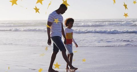 Walking barefoot father and child on sunlit beach with gold stars overlay