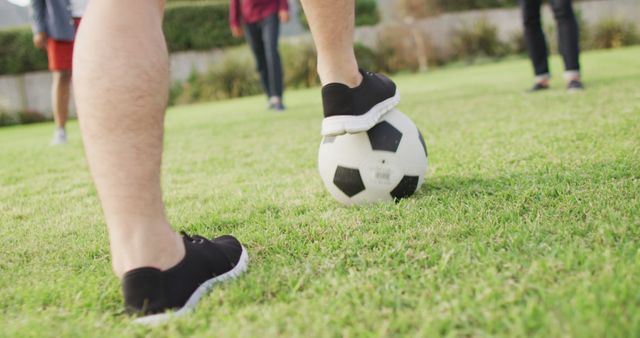 Youth kicking soccer ball on green grass at local park, emphasizing active lifestyle. Perfect for themes involving outdoor activities, teamwork, sports, and childhood. Ideal for marketing campaigns, educational materials, sports ads, and healthy living content.
