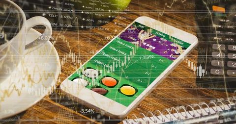 Displaying mobile betting app on smartphone with stock market overlay, coffee cup and poker chips