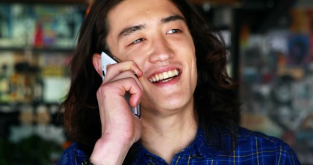 Smiling Young Man Talking on Phone in Urban Cafe - Download Free Stock Images Pikwizard.com