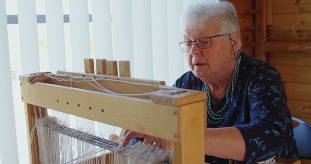 Elderly Woman Weaving on Traditional Loom in Well-Lit Room - Download Free Stock Images Pikwizard.com