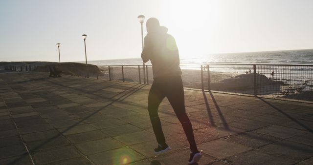 Silhouette of Man Exercising Outdoors at Sunset by Ocean - Download Free Stock Images Pikwizard.com