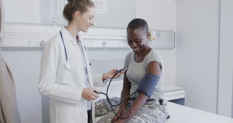 Doctor checking patient's blood pressure in hospital setting