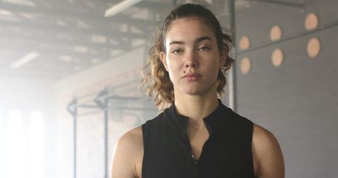 Strong Woman in Industrial Warehouse Gym with Pull-Up Rig