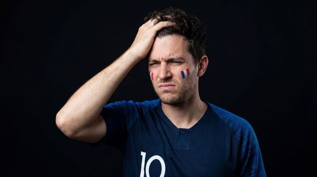 Frustrated french football fan holding head wearing number 10 jersey closeup