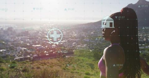 Standing fit woman overlooking coastal city from hillside wearing earbuds and ar hud