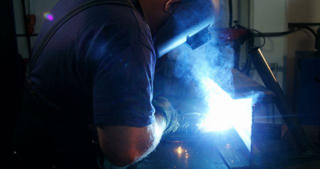 Welder wearing protective gear working on metal with welding torch - Download Free Stock Images Pikwizard.com