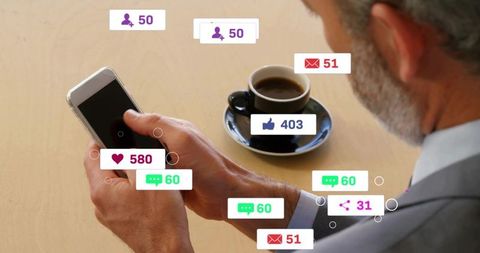 Senior businessman checking smartphone with social media notifications over coffee