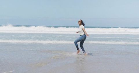Woman Enjoying Beach in Jeans and T-Shirt