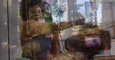 Woman reflecting through window with forest double exposure conveying tranquil contemplation