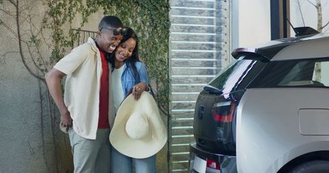 Joyful Couple Enjoying Leisure Time by Modern SUV Outdoors