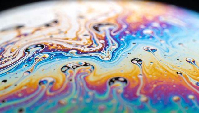 Iridescent soap film swirling macro closeup rainbow interference abstract surface texture