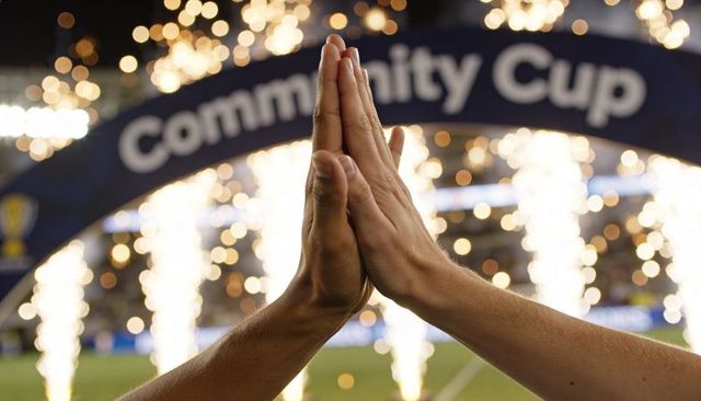 Pressing palms together celebrating team victory under stadium sparkler arch