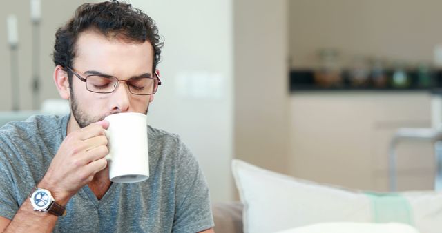 Young Man Sipping Coffee at Home Relaxing - Download Free Stock Images Pikwizard.com