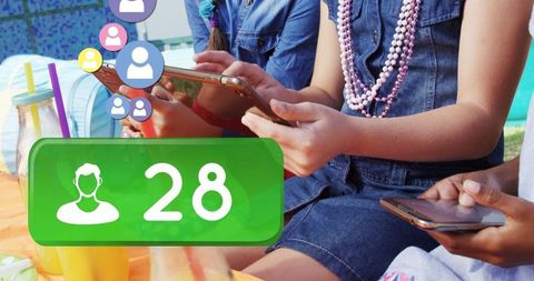 Teenagers socializing outdoors engaged with smartphones