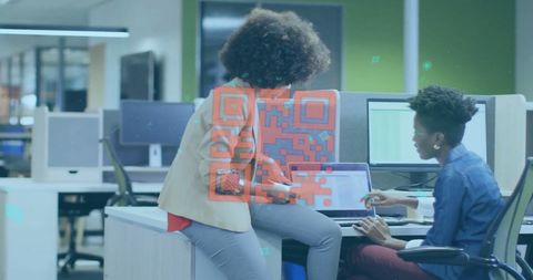 Businesswomen Collaborating with QR Codes in Modern Office