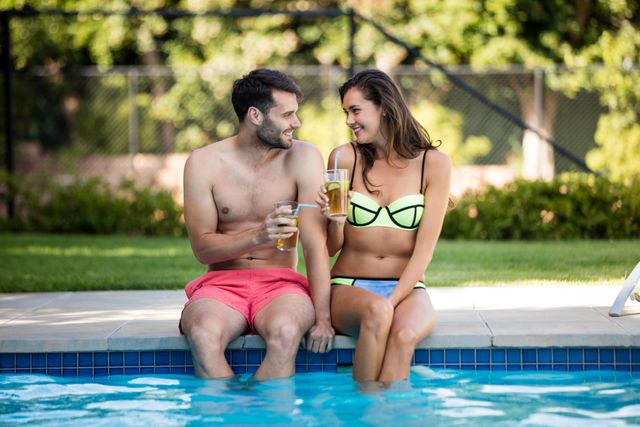 Young couple having iced tea at poolside - Download Free Stock Photos Pikwizard.com