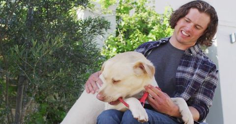 Man Enjoying Companionship with Dog on Sunny Outdoor Bench