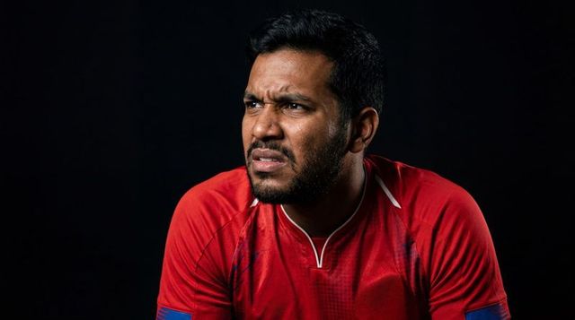 Intense indian athlete grimacing in red jersey showing frustration, focus and tension