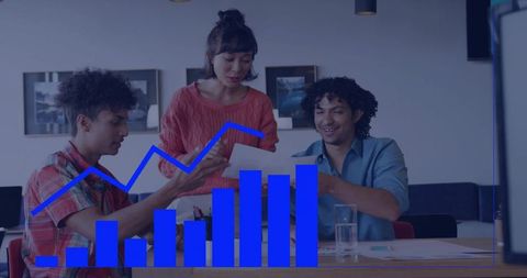 Team collaborating over documents with blue chart overlay in coworking meeting