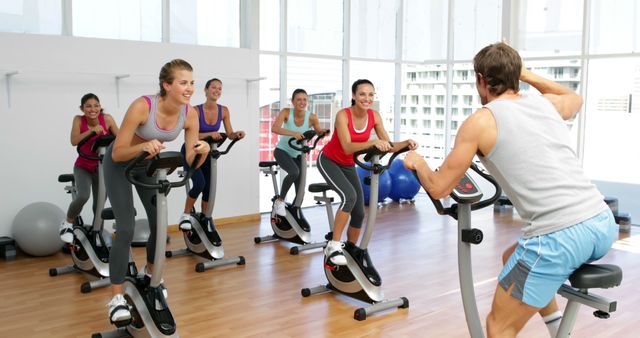 Group of Women Participating in Indoor Cycling Class with Instructor - Download Free Stock Images Pikwizard.com