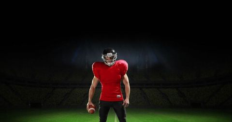 Determined American Football Player in Red Jersey on Field at Night