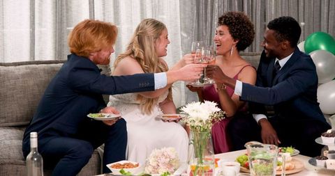 Newlyweds Toasting with Friends at Intimate Wedding Reception in Living Room