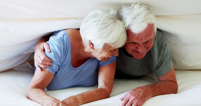 Happy Senior Couple Embracing Under Blanket Sharing Intimate Moment - Download Free Stock Images Pikwizard.com