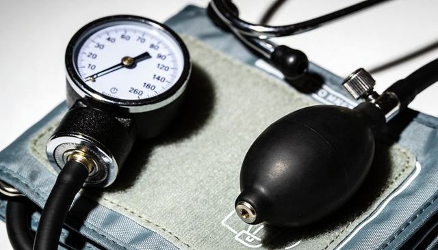 Displaying manual sphygmomanometer close-up featuring aneroid gauge rubber bulb and cuff