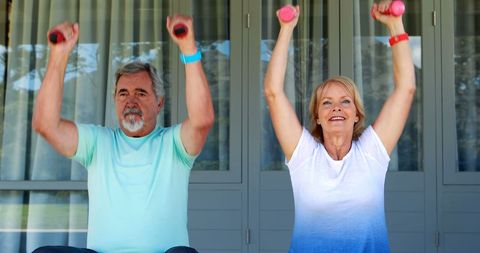 Senior Couple Staying Fit with Dumbbell Exercises Outdoors